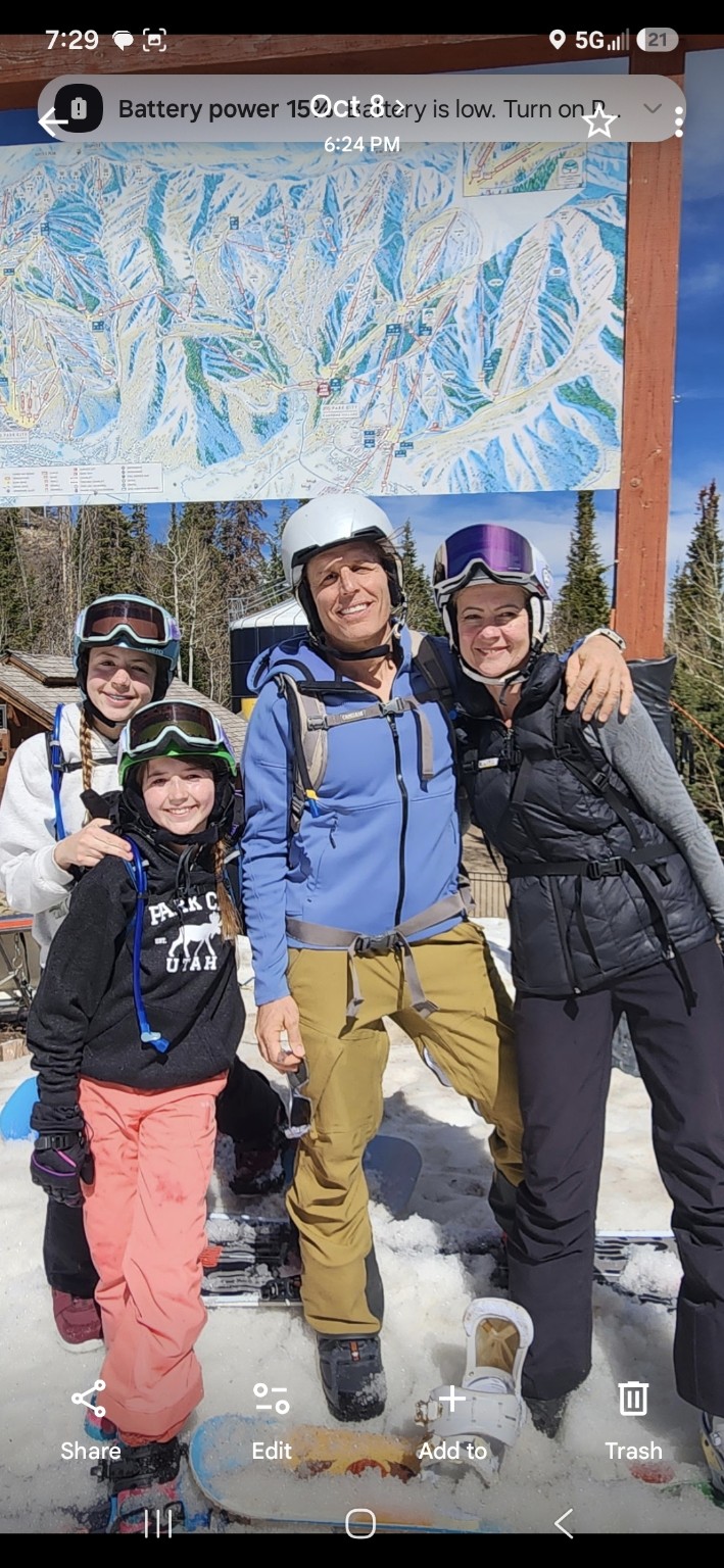 Karina, Jamie, and their two daughters skiing together on a family vacation